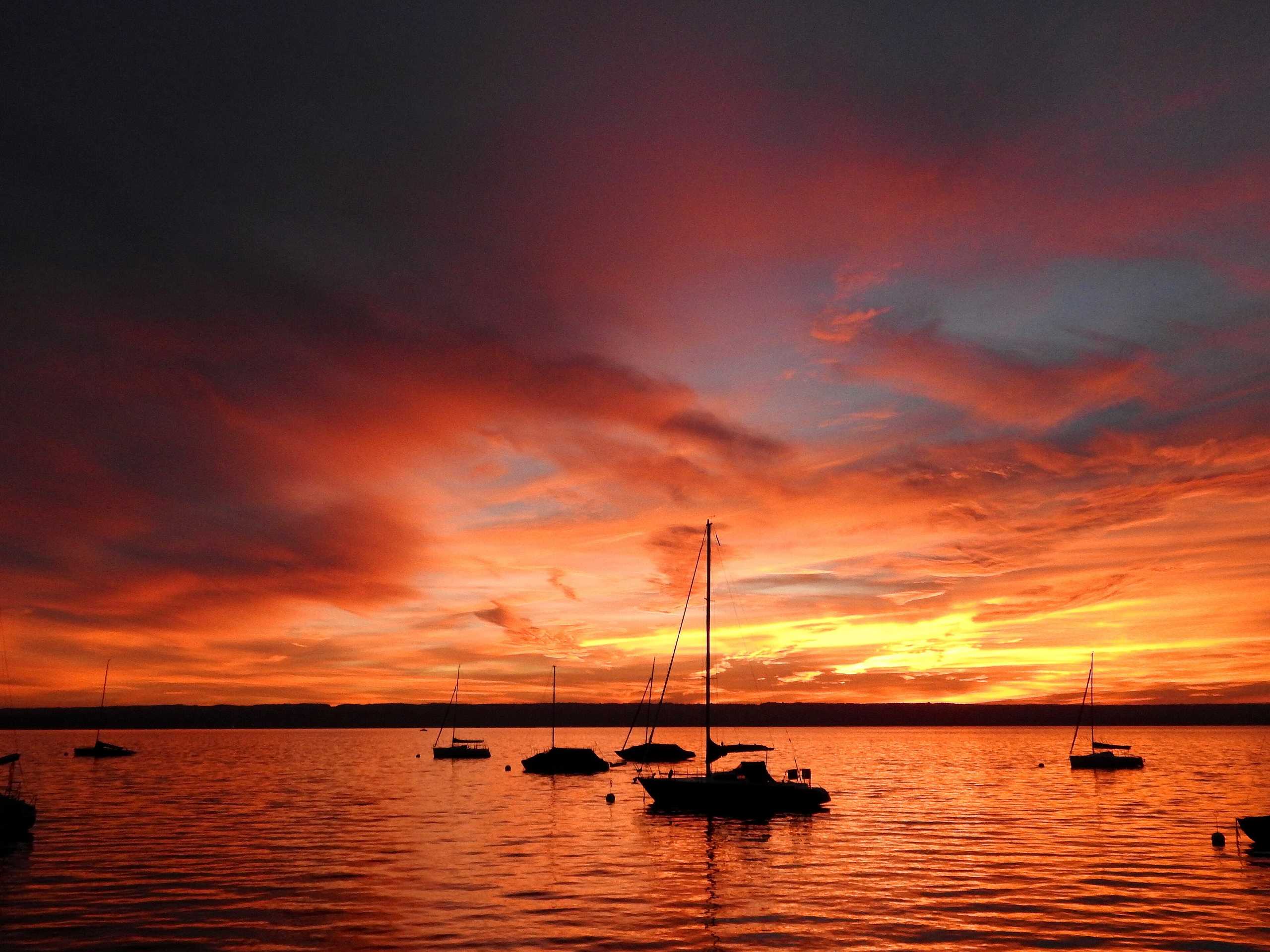 Sonnenuntergang über dem Ammersee mit Segelbooten